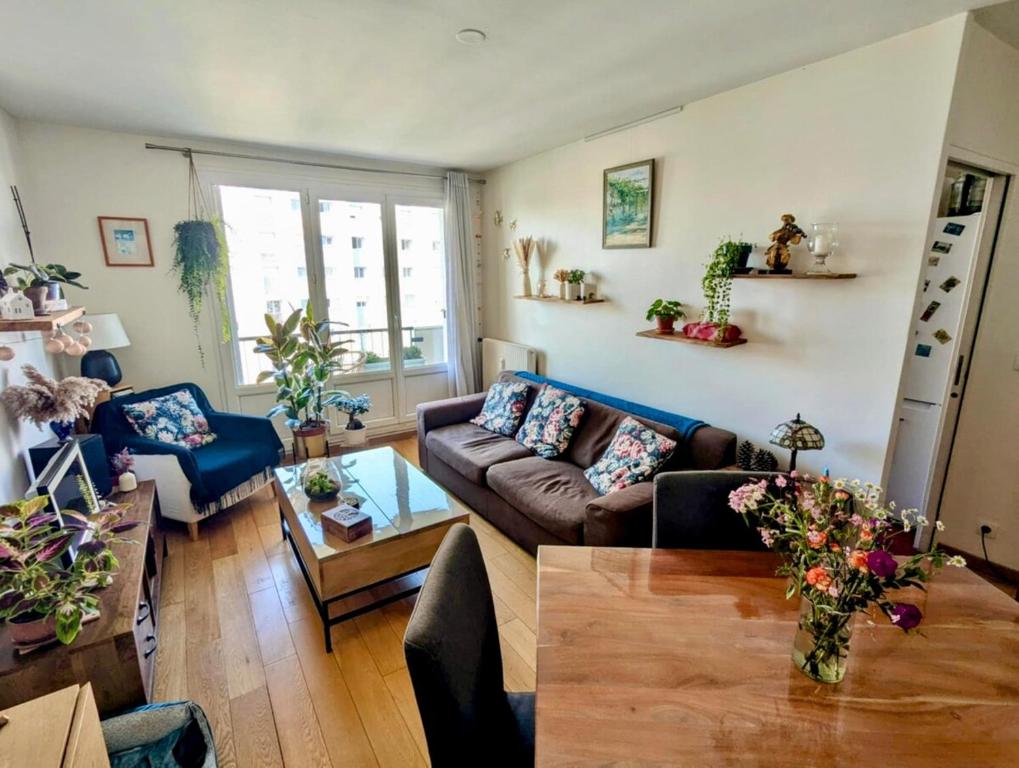 un salon avec un canapé et une table dans l'établissement Spacieux appartement balcon, à Paris