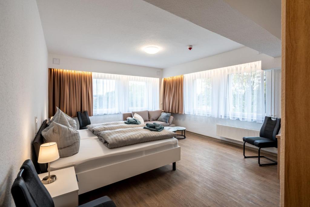 a bedroom with a bed and a couch and windows at Pension Resort Dreistern in Göda