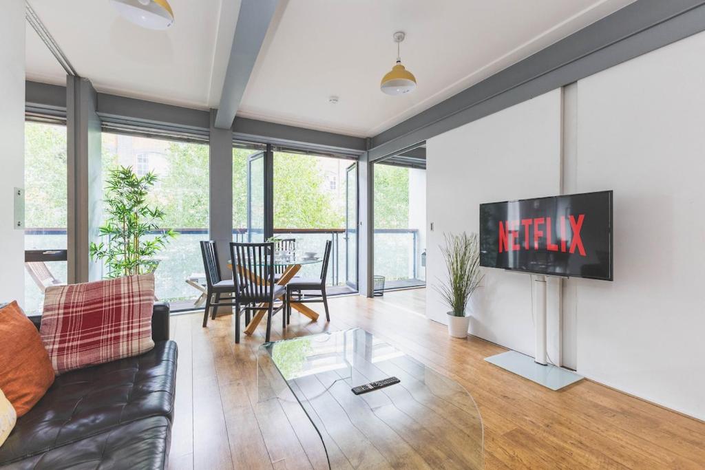 Hotel 2Bed Stratford Apt with Easy Access to Central London, O2, ExCel, Parking Nearby, a living room with a couch and a tv on a wall at 2Bed Stratford Apt with Easy Access to Central London, O2, ExCel, Parking Nearby in London