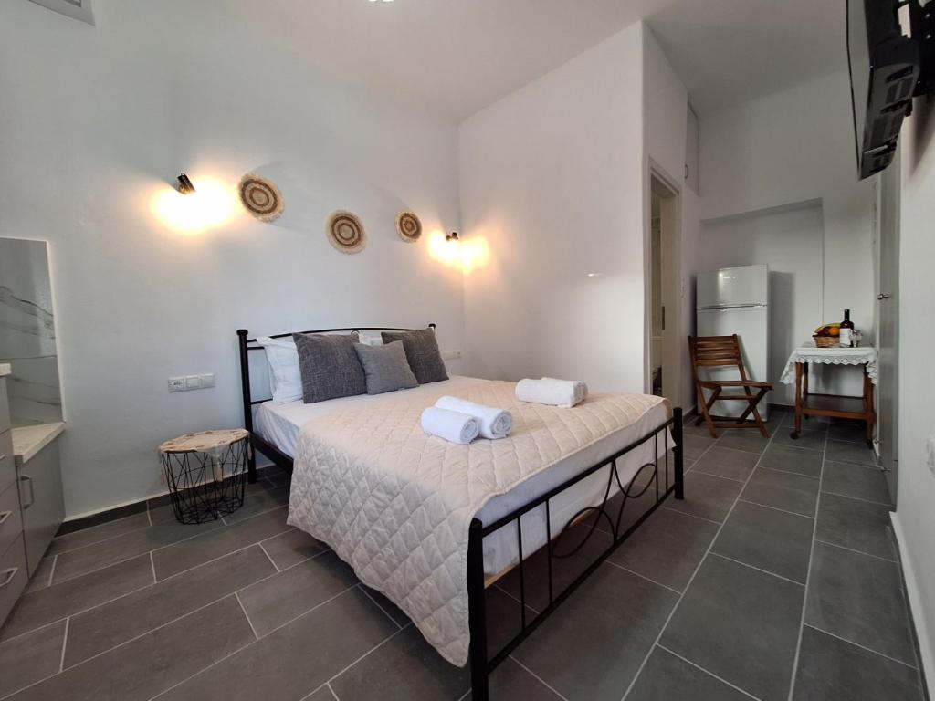 a bedroom with a bed with two towels on it at Aegean Traditional Suite Ιn Glinado in Glinado Naxos