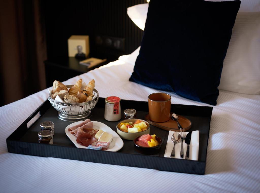 a tray of food on top of a bed at Hôtel Villa M Marseille in Marseille