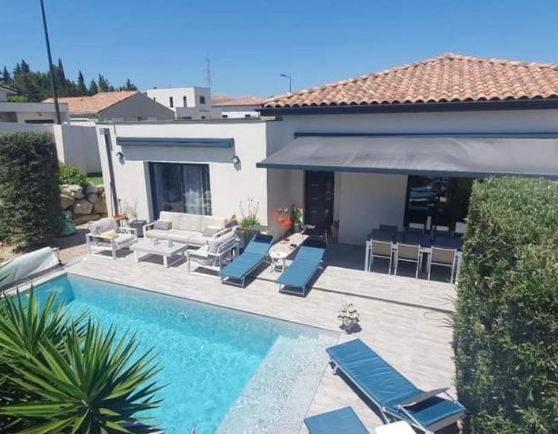 une piscine avec des chaises longues et une maison dans l'établissement Maison agréable et paisible, à Carcassonne