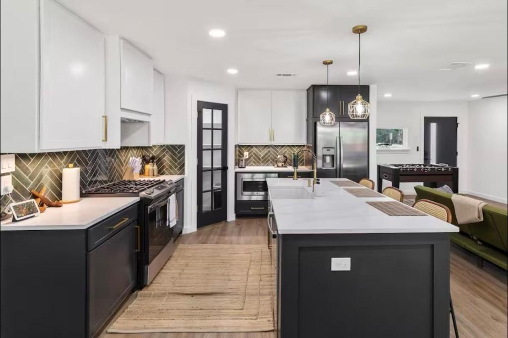 cocina con electrodomésticos en blanco y negro y sala de estar. en Luxury Oasis 4B 2B Jacuzzi Pet Friendly, en Plano