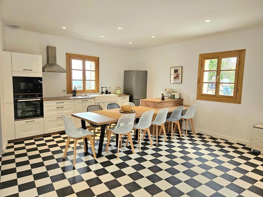 a kitchen with a table and chairs in a kitchen at Magnifique villa avec piscine- hauteurs de Bastia in Bastia