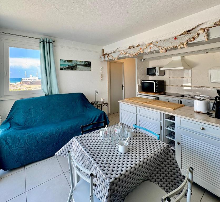 un salon avec une table et une cuisine dans l'établissement Superbe T2 face mer 4EST402, au Barcarès
