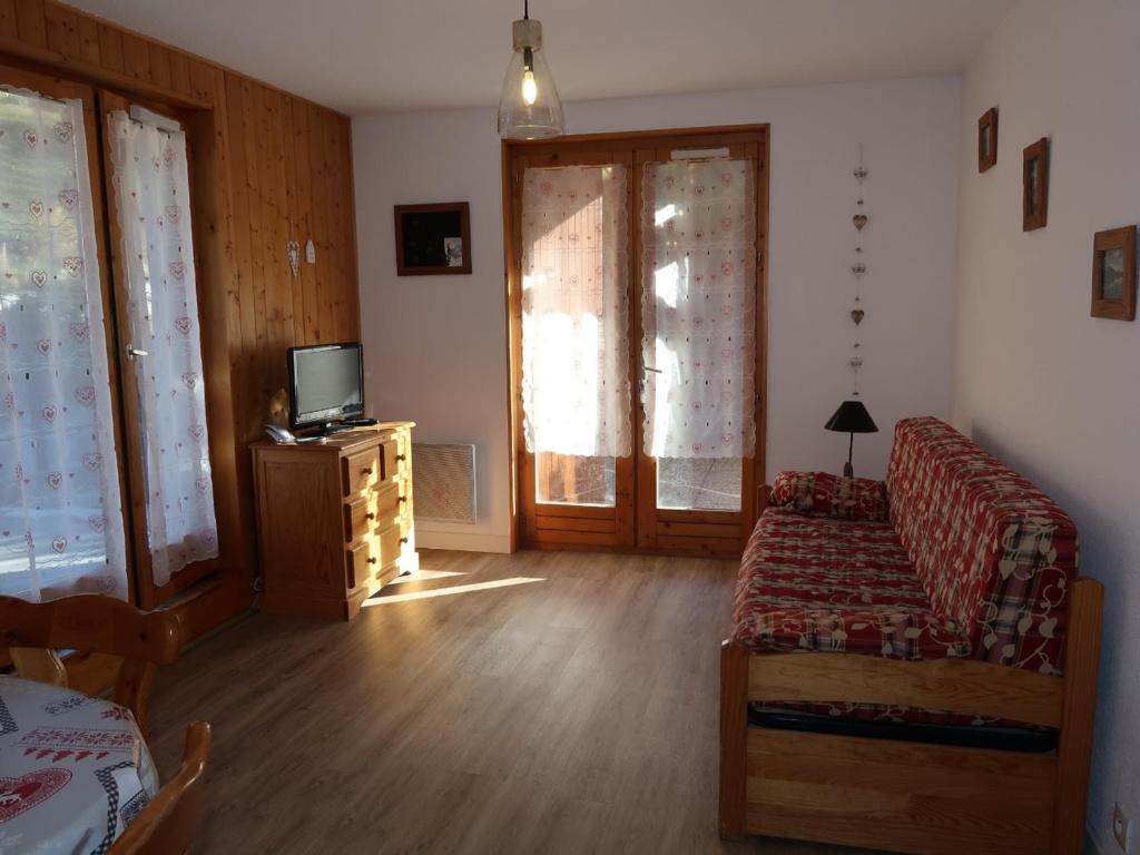 un salon avec un canapé et une télévision dans l'établissement Appartement familial 3 pièces pour 8 personnes, terrasse et parking, centre de Valloire - FR-1-263-455, à Valloire
