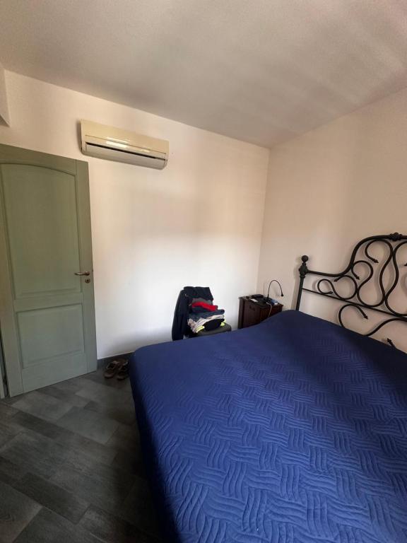 a bedroom with a blue bed and a door at La Praia Favignana in Favignana
