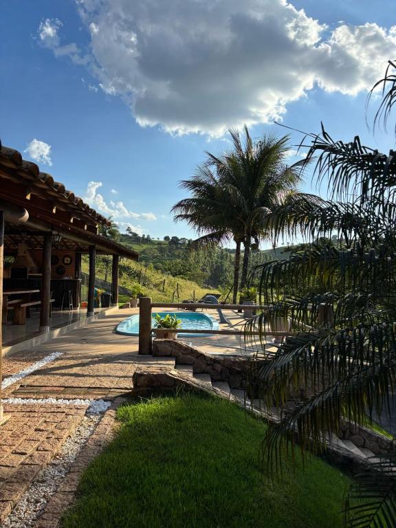 a resort with a swimming pool and palm trees at Sítio Céu da Mantiqueira in Espirito Santo Do Pinhal