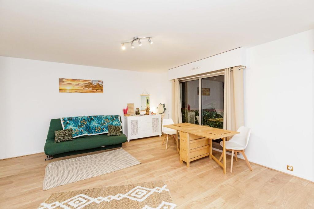 un salon avec un canapé vert et une table dans l'établissement Apartment near Buttes Chaumont, à Paris