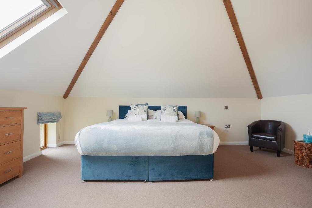 una camera da letto con un letto grande in una mansarda di Beautiful Barn Conversion with Games Room a Ilfracombe
