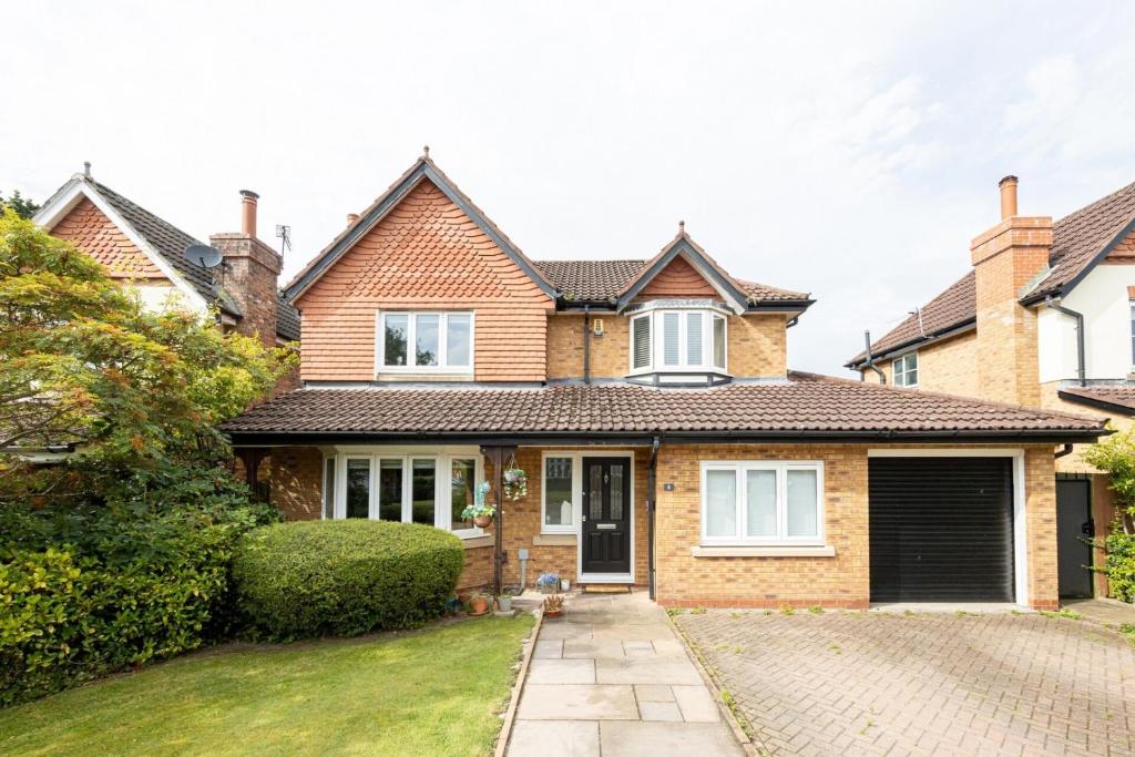 a bedroom house with a garage and a driveway at Modern Family Home in South Manchester/Stockport in Cheadle