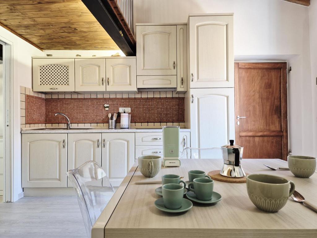 Una cocina con gabinetes blancos y una mesa de madera. en Casa Lorenzo, en Rio Marina
