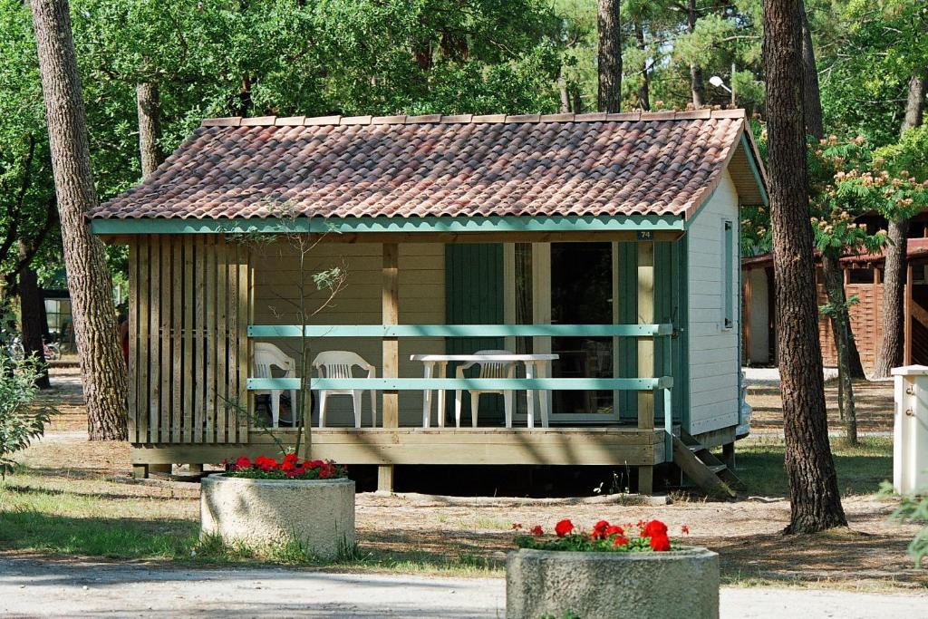 滨海苏拉克Camping Les Oyats的公园里摆放着椅子和鲜花的小棚子