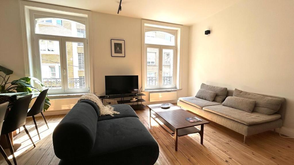 un salon avec un canapé et une table dans l'établissement Charlotte - Grand T4 à 5 Mn à pieds gare TGV, à Lille