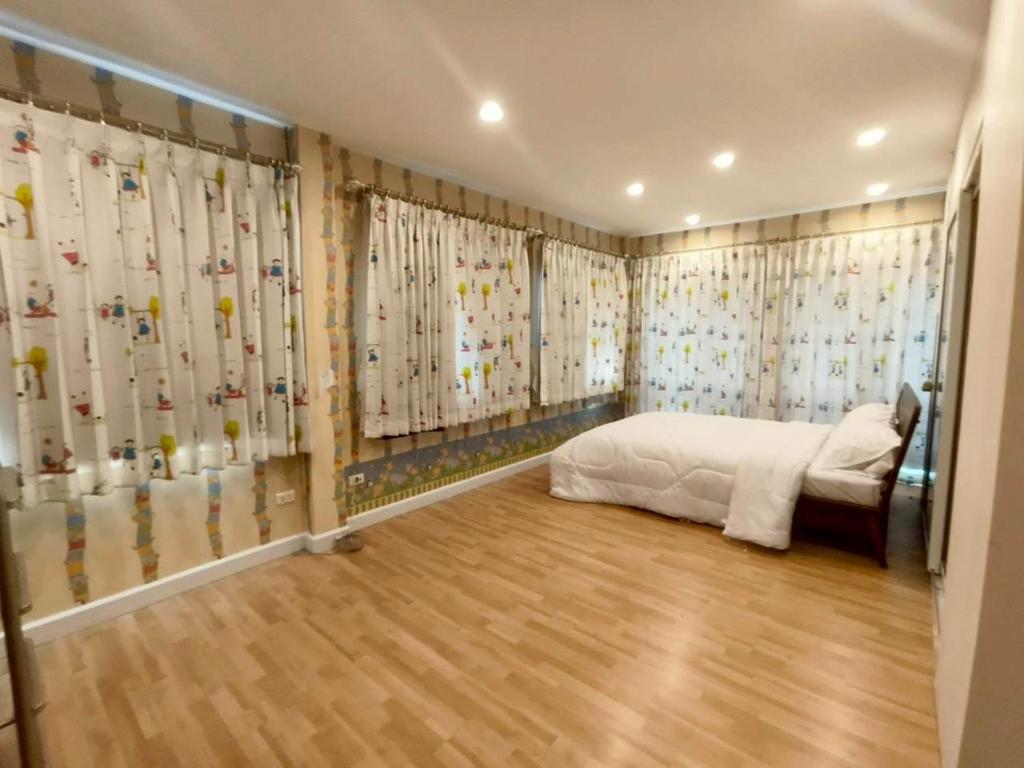 ein Schlafzimmer mit einem Bett und Vorhängen mit Vögeln darauf in der Unterkunft The Lanna Lagoon เดอะลานนา ลากูน in Chiang Mai