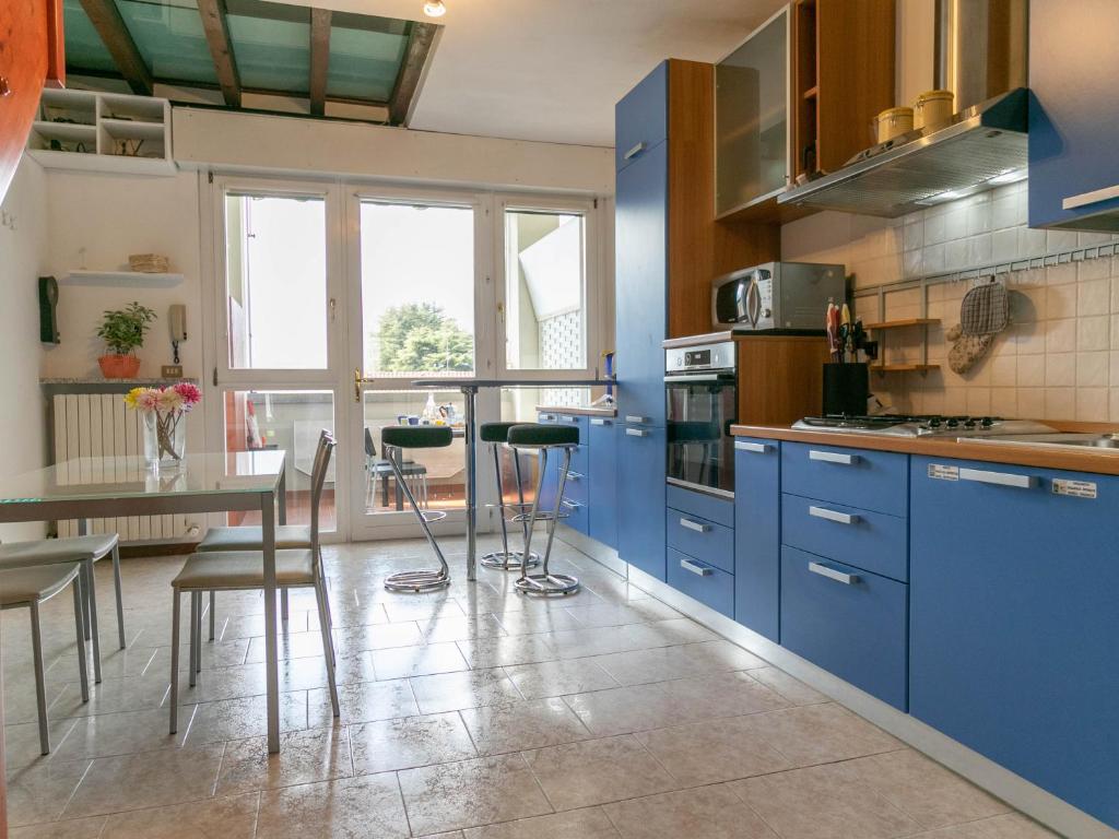 a kitchen with blue cabinets and a table with chairs at KG Lierna Lake View in Lierna