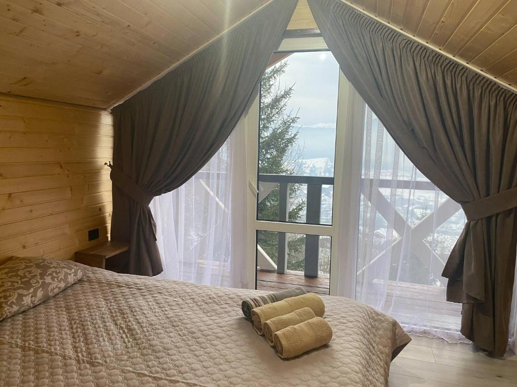 a bedroom with a bed in front of a large window at Шпінь 4 in Vorokhta