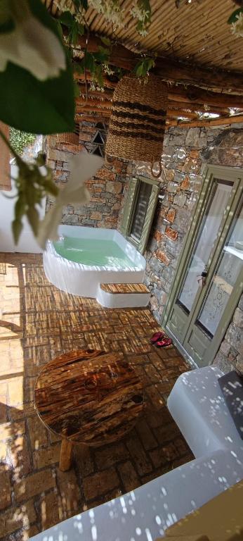 a stone building with a bath tub in a room at Aliori art caves in Aegiali