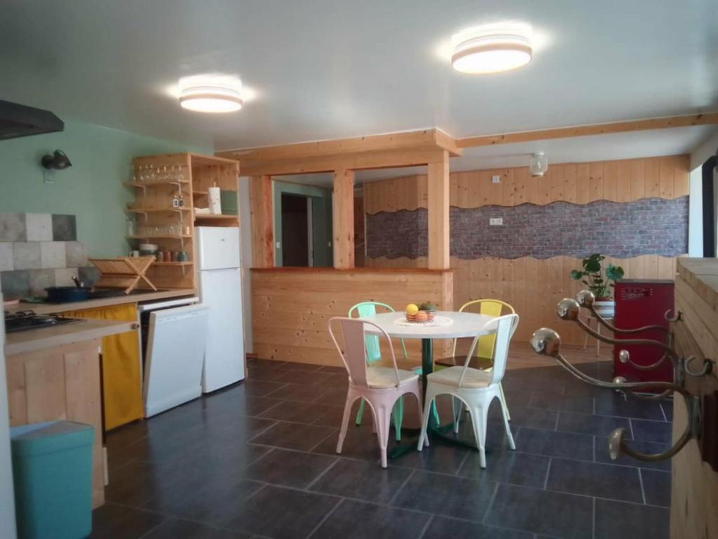 a kitchen with a table and chairs in a kitchen at L'atelier des couleurs in Vagney
