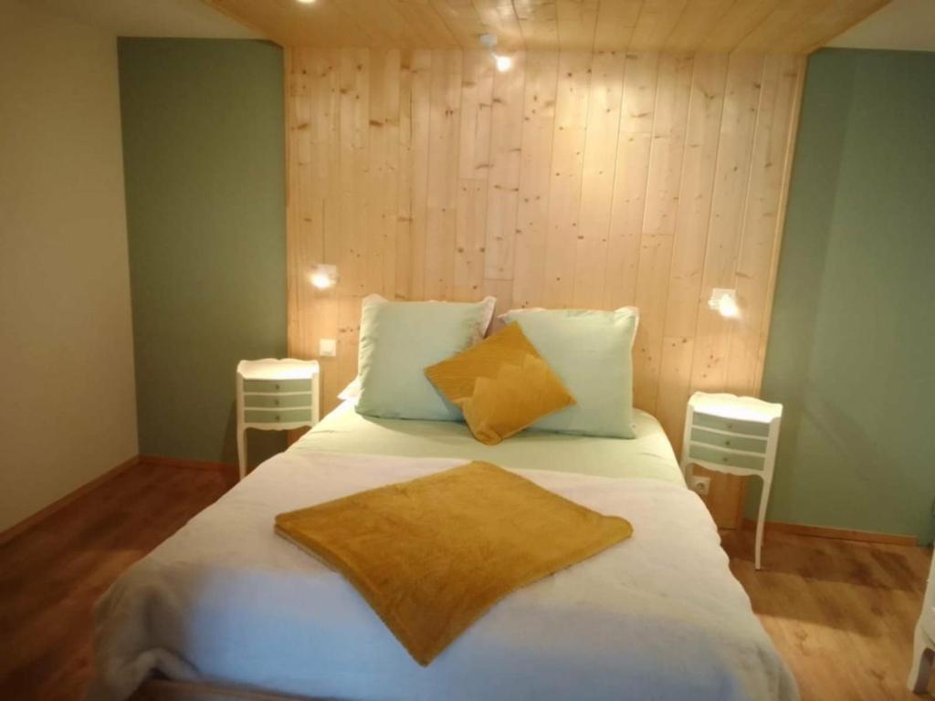 a bedroom with a large white bed with two pillows at L'atelier des couleurs in Vagney