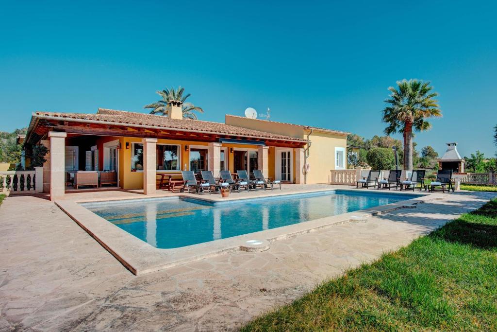 a house with a swimming pool in front of a house at Ca na Margalida in Manacor