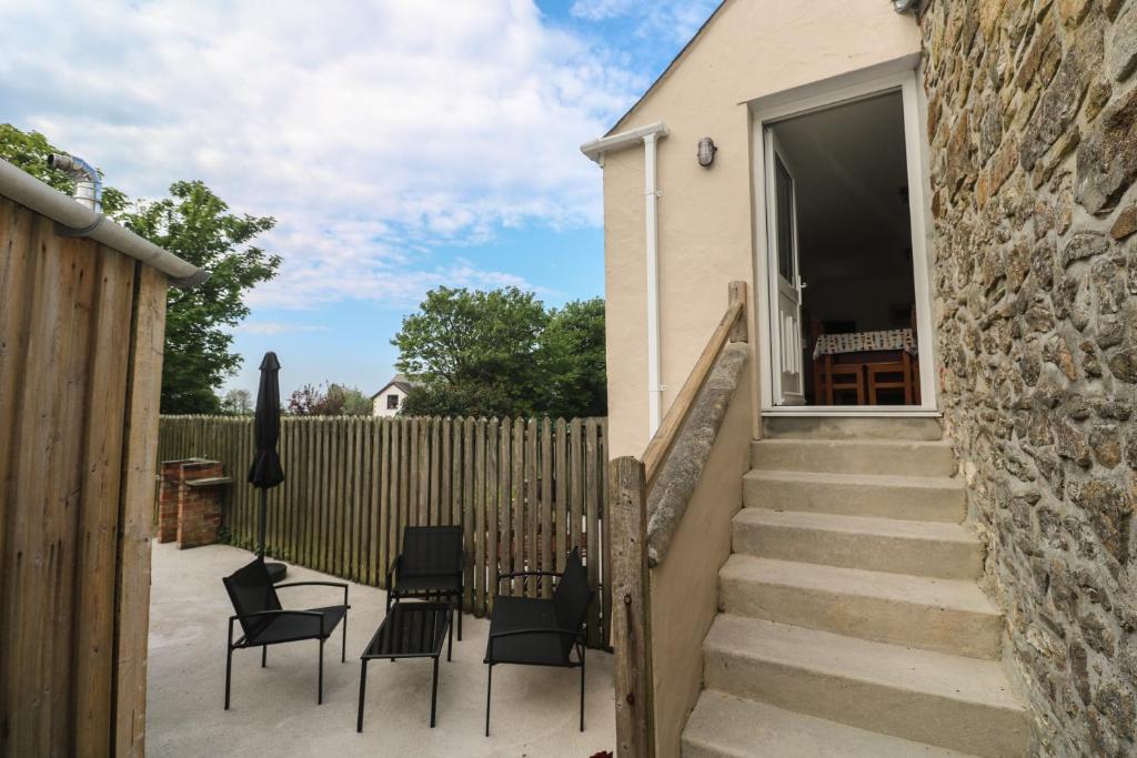 a patio with chairs and a fence at Sea View Loft in Penzance