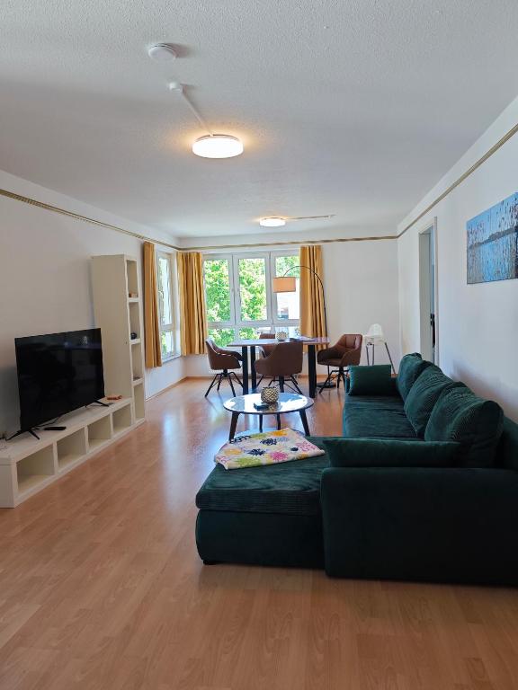 a living room with a green couch and a table at Ferienwohnung Bad Saarow "Am Märkischen Meer" in Bad Saarow
