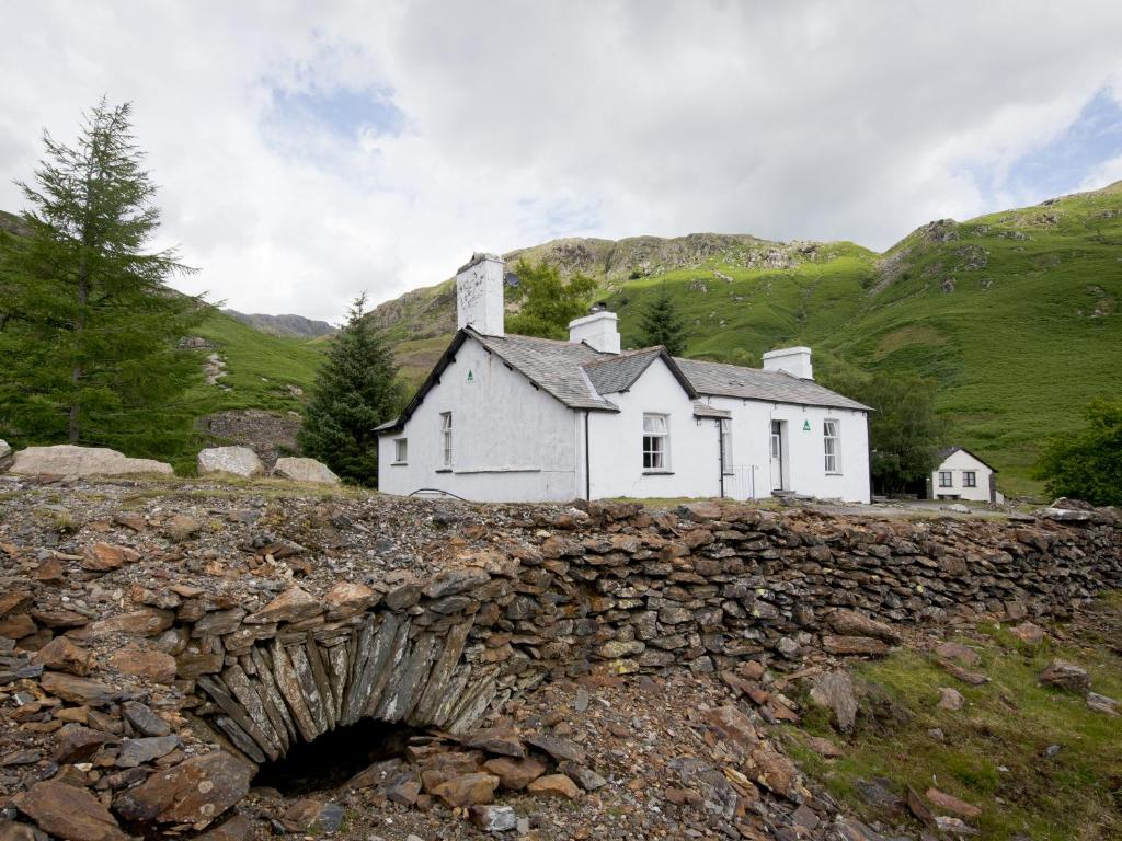 a white house on the side of a hill at YHA Coniston Coppermines in Coniston