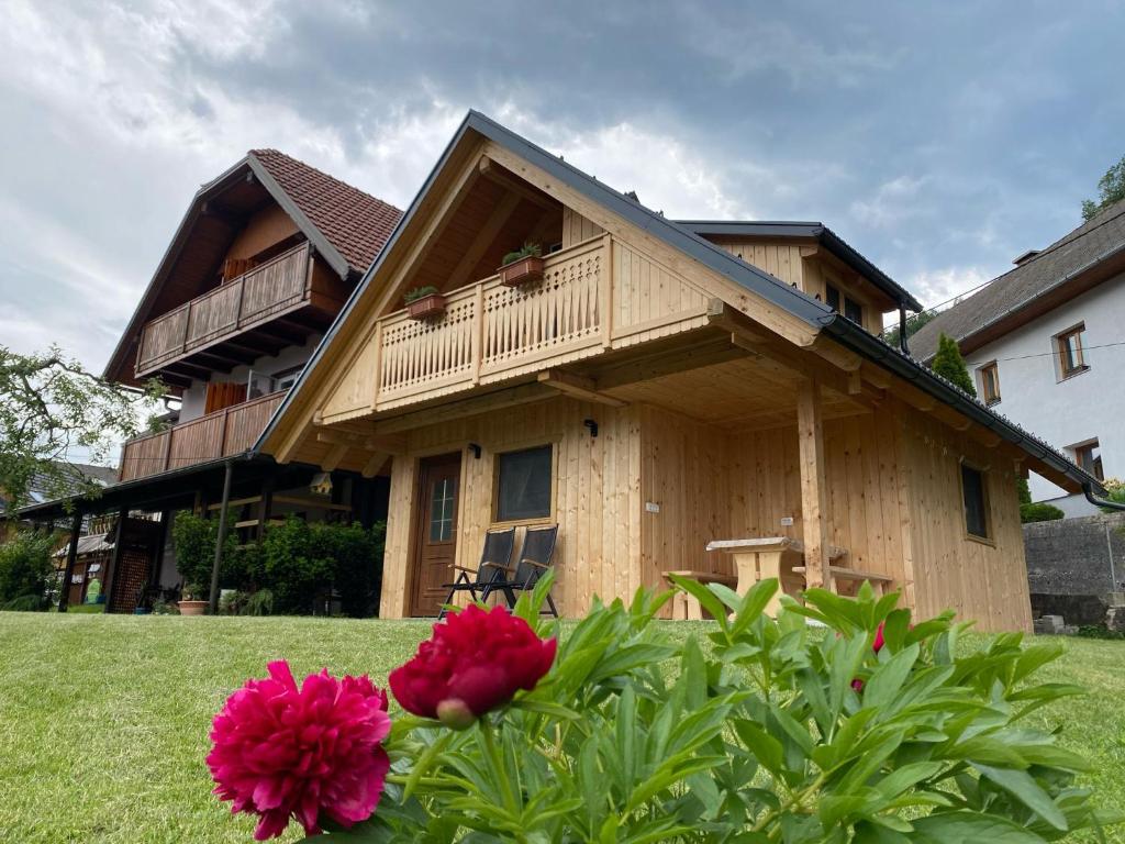 a wooden house with a balcony and some flowers at Princess Mojca Holiday House in Bled