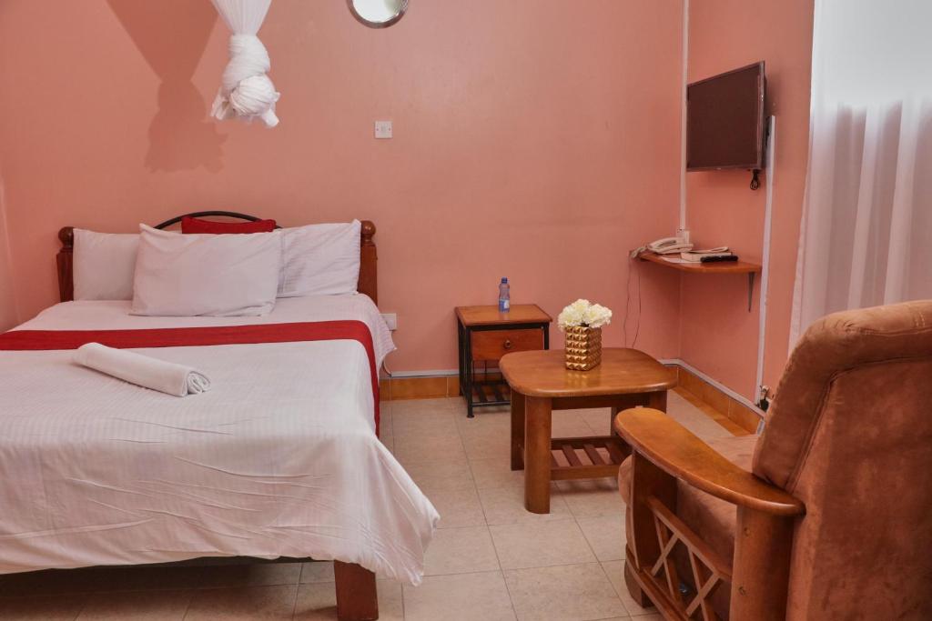 a hotel room with a bed and a chair at 136 Boutique Address Hotel in Nairobi