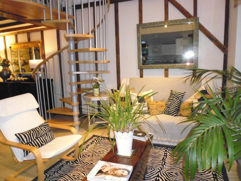 ein Wohnzimmer mit einer Treppe und einem Tisch und Stühlen in der Unterkunft Wonderful Picturesque Countryside Cottage in Bloxham