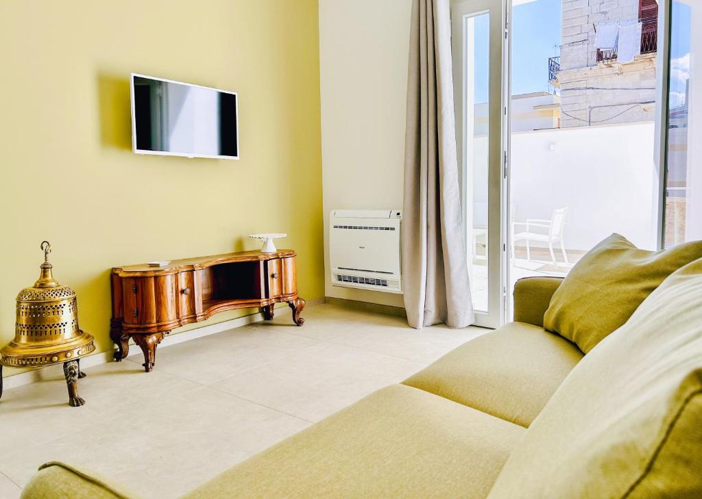 een woonkamer met een bank en een tv bij L'Ancora appartamenti 5 in Giovinazzo