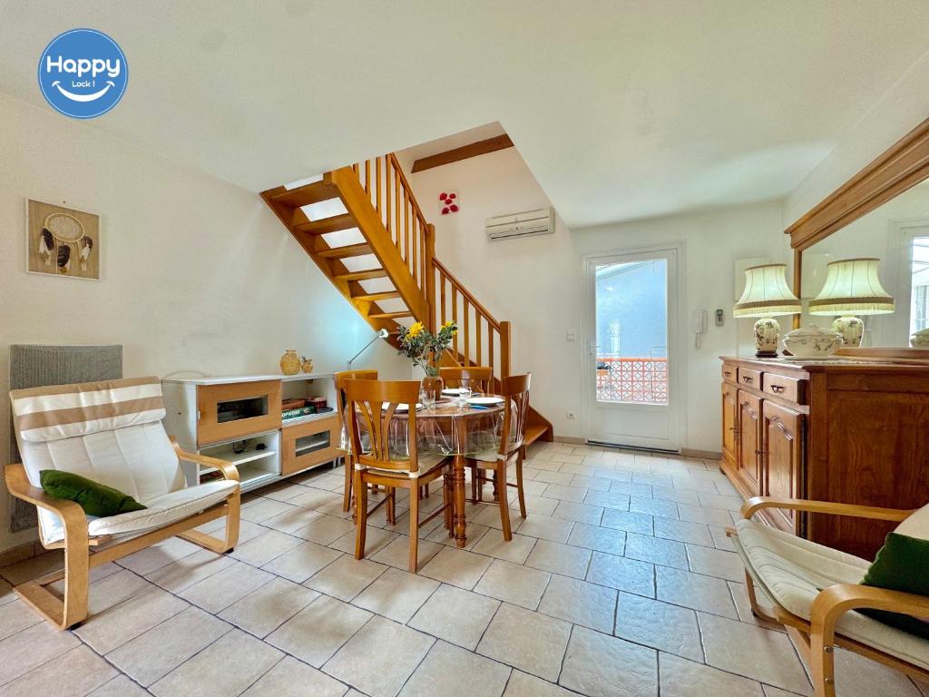 un salon avec une table et un escalier dans l'établissement Alice Proche Grotte Salamandre & Aven d'Orgnac, à Saint-Jean-de-Maruéjols-et-Avéjan