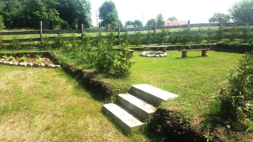 a garden with a bench in the grass at Domek nad jeziorem, mazury in Szczytno