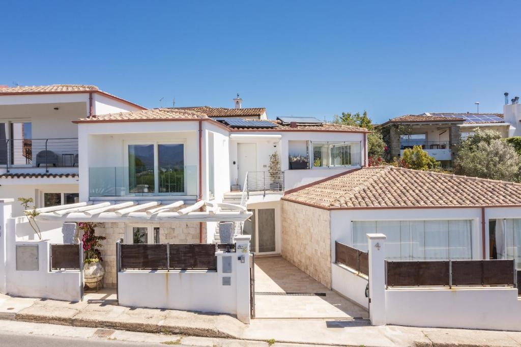 a large white house with a lot of windows at Casa Vacanze Zeffiro vista mare con giardino in Àrbatax