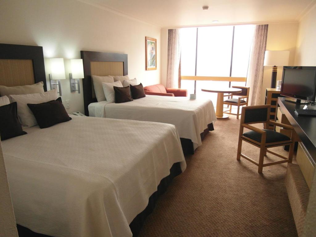 a hotel room with two beds and a television at Hotel Royal Reforma in Mexico City
