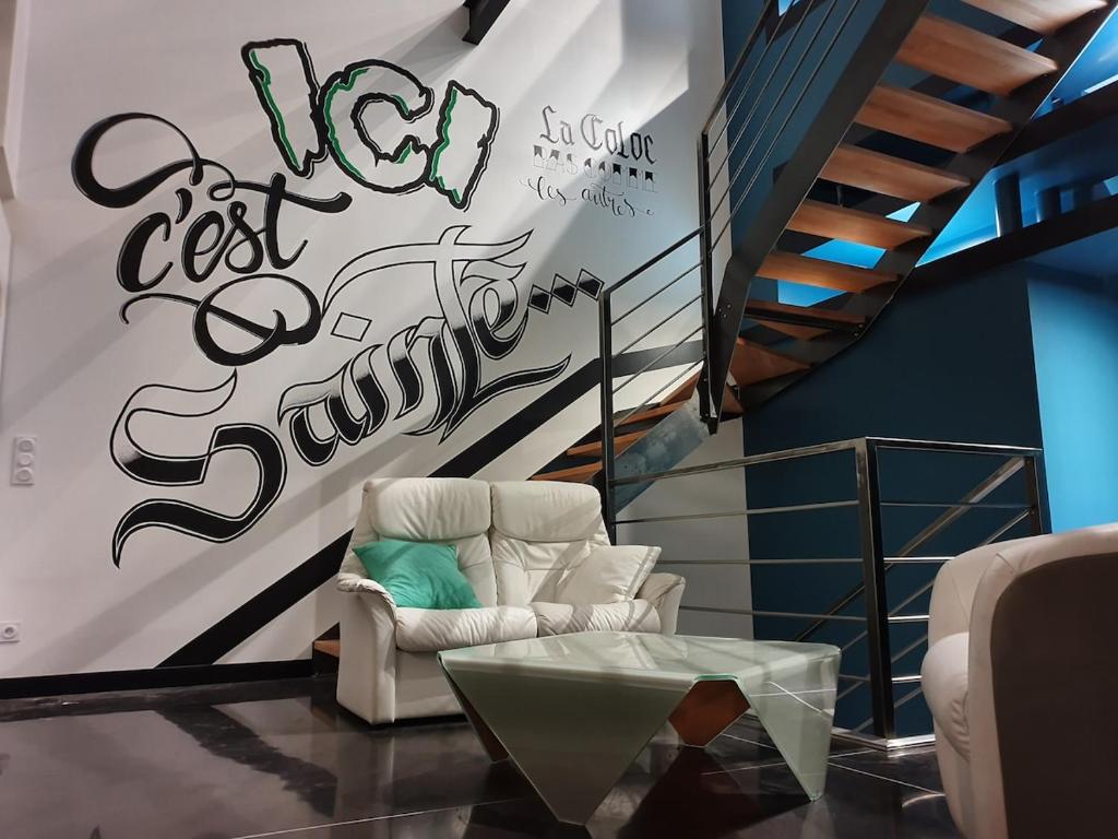 サン・テティエンヌにあるLuxury loft with a gymの椅子と落書きのある壁のあるリビングルーム