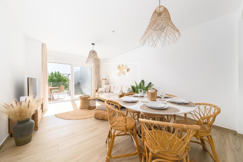 un soggiorno bianco con tavolo e sedie di Boho Breeze Penthouse - By Oyoostays a Pilar de la Horadada
