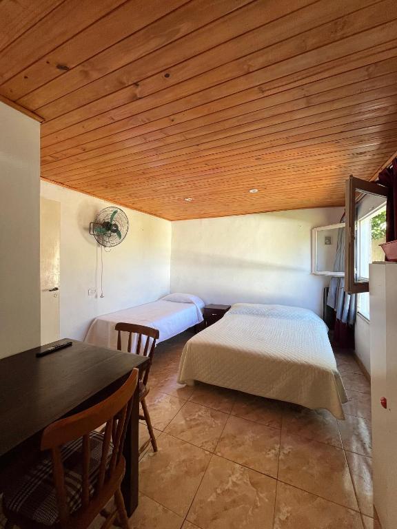 a room with two beds and a table and a dining room at Apart Los lirios in La Porteña
