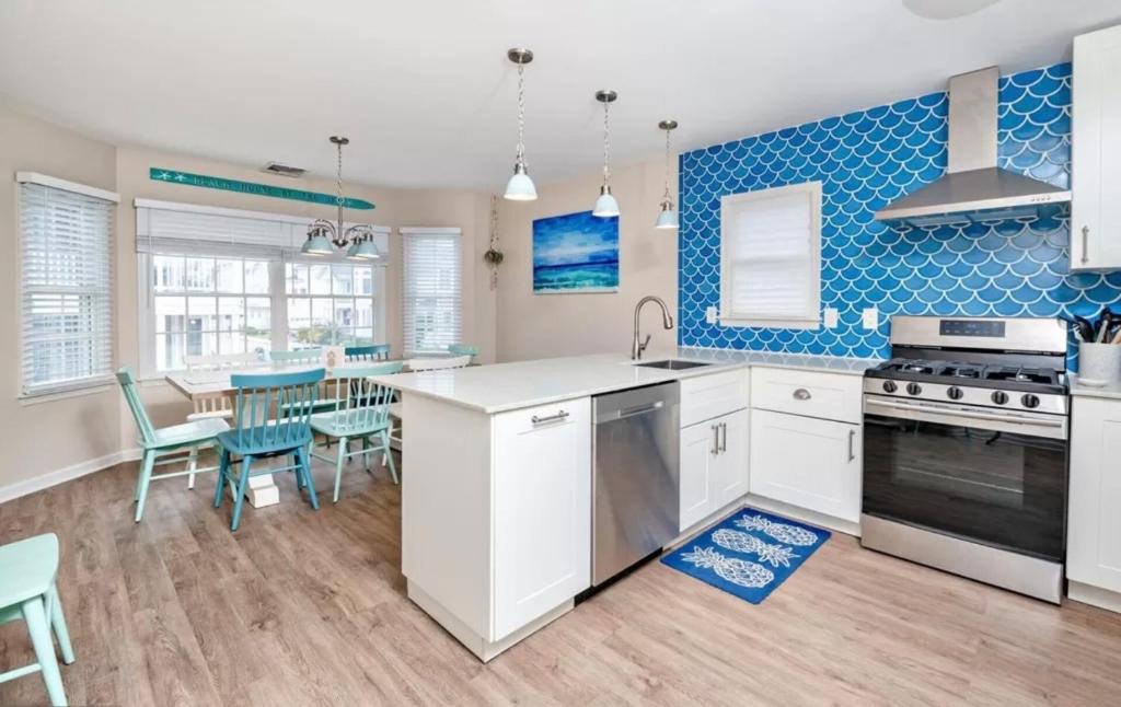eine Küche mit weißen Schränken und blauen Fliesen in der Unterkunft Surfside Retreat- Close to Beach & Boardwalk! in Atlantic City