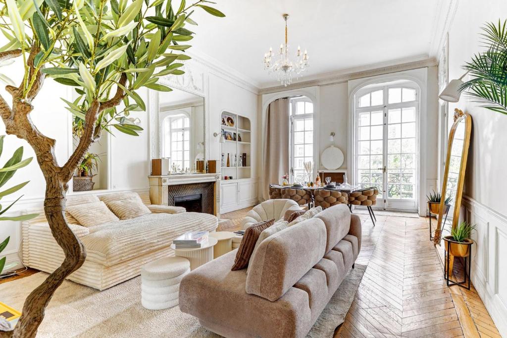 - un salon avec un canapé et un arbre dans l'établissement L'Ecrin Wagram Suite, à Paris