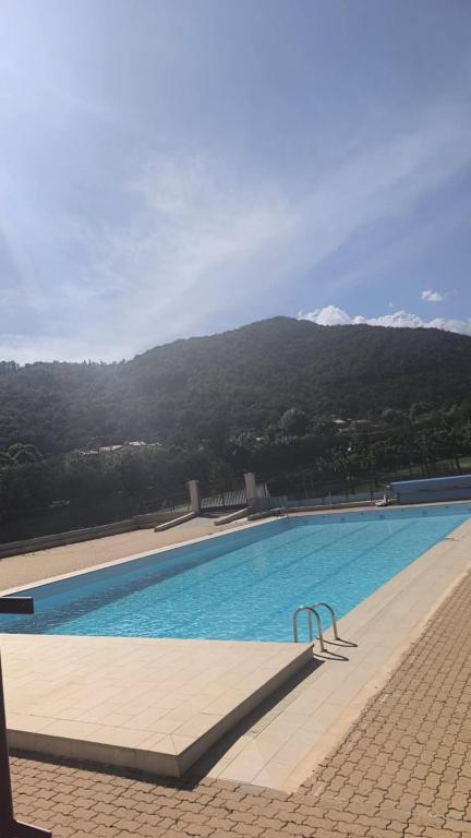 une grande piscine avec des montagnes en arrière-plan dans l'établissement Villa 2 chambres piscine municipale à 500 m, à Arles-sur-Tech