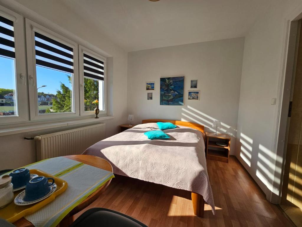 a bedroom with two beds and two windows at Pokoje gościnne in Międzyzdroje