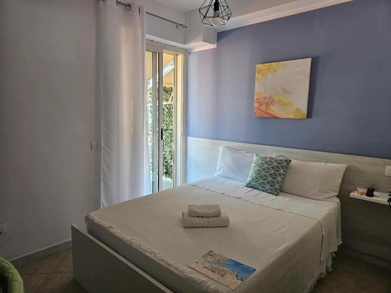 a bedroom with a large bed with a blue wall at Blue Tide - Tropea in Tropea