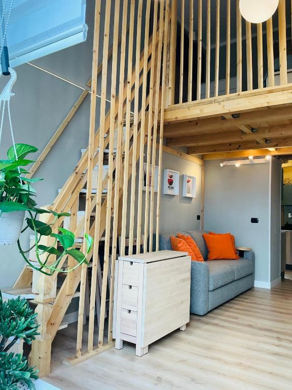 a living room with a couch and a staircase at CityLoft Milano, two meters from metro station for the Duomo in Milan
