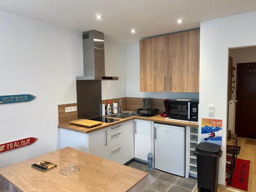 une cuisine avec des armoires blanches et un comptoir dans l'établissement Studio proche des pistes - Chantegrive, à Uvernet