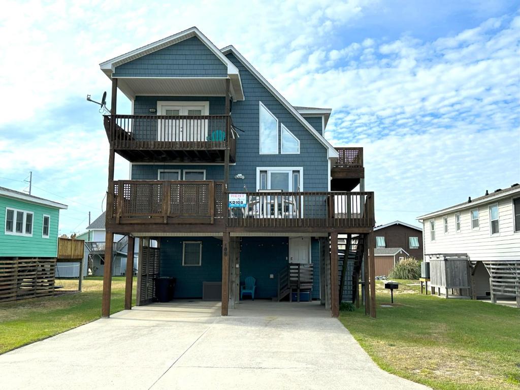 a blue house with a deck and a balcony at KD108- Into the Mystic in Kill Devil Hills