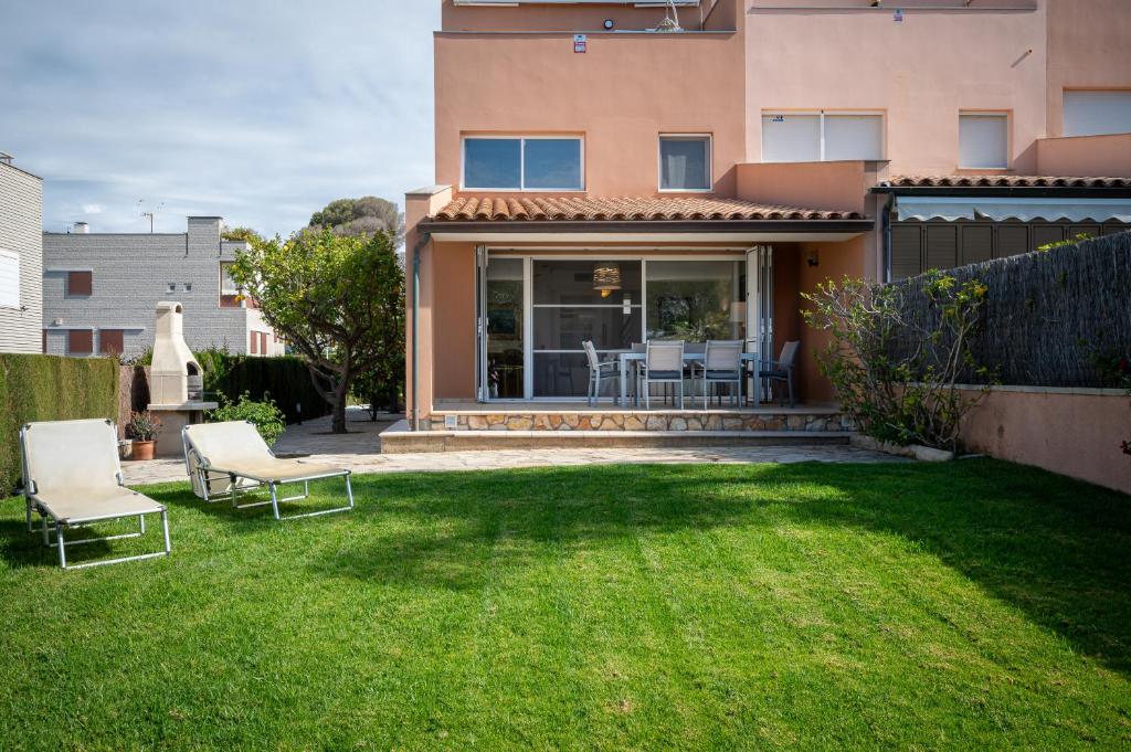 a yard with two chairs and a house at AT009 Rebolç in Torredembarra