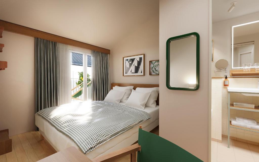 a small bedroom with a bed and a mirror at Alfred Hotels Toulouse Centre Wilson in Toulouse