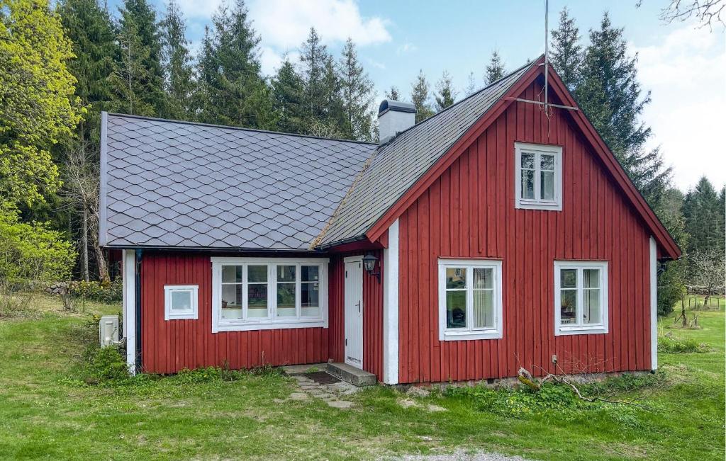 a red house with a black roof at Nice Home In Lidhult With Kitchen in Ljunghult